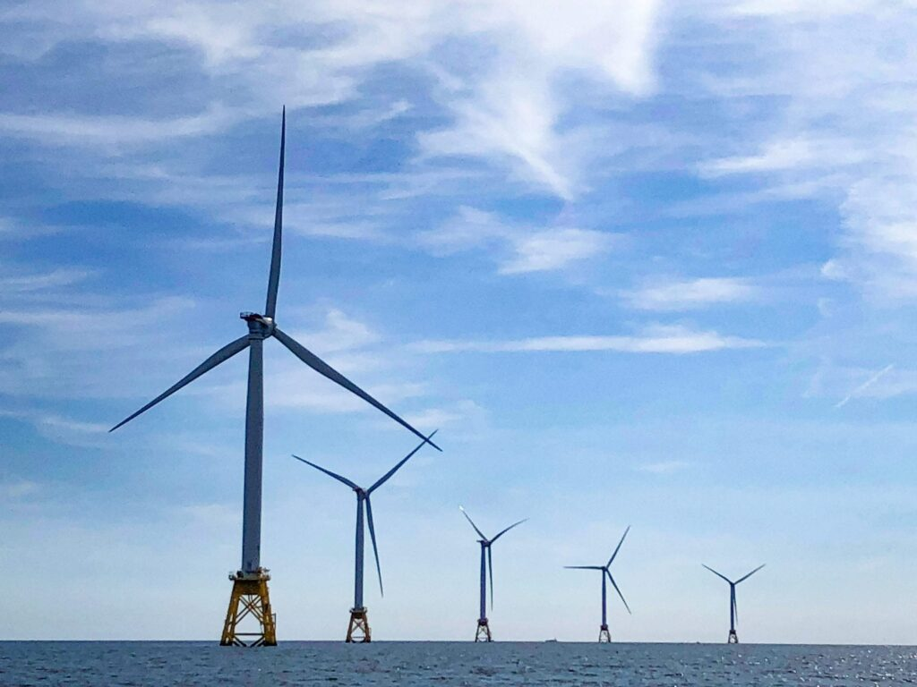 A group of wind turbines in the ocean Description automatically generated with medium confidence