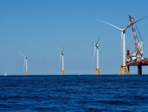 A group of wind turbines in the ocean Description automatically generated